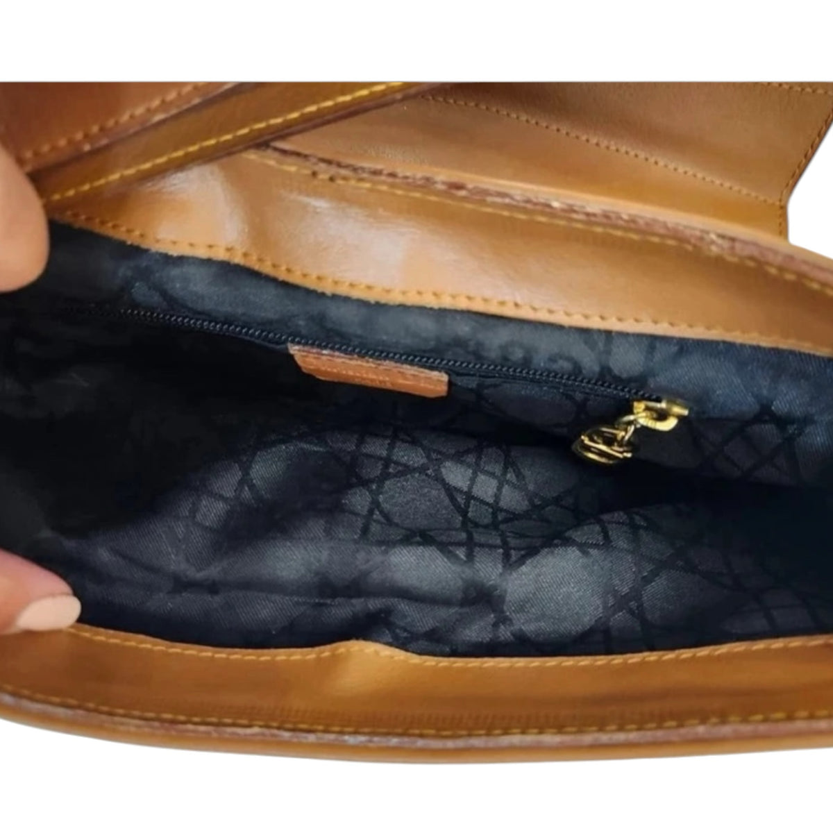 Interior of a Fivedotsvintage Christian Dior brown leather shoulder bag with black signature patterned fabric lining