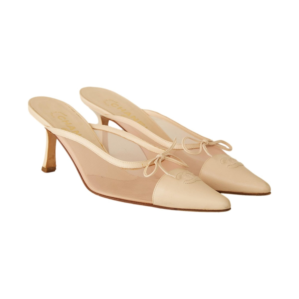 Fivedotsvintage beige CHANEL pointed-toe mules featuring sheer mesh panels, leather trim, a bow, and a kitten heel.