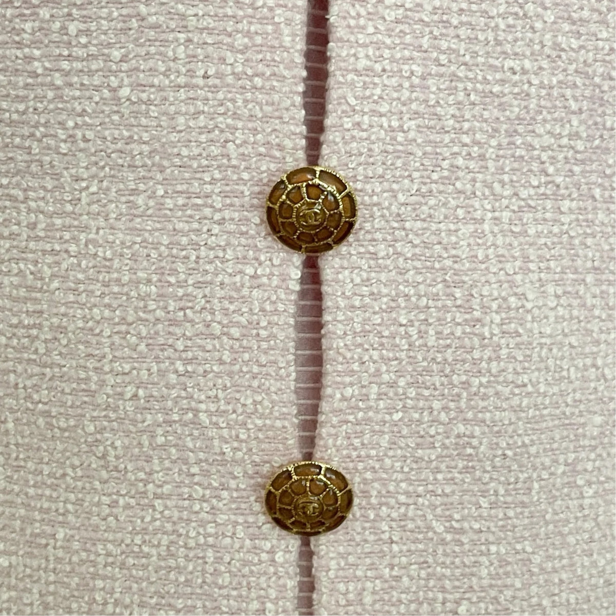 Fivedotsvintage pastel pink textured tweed fabric with iconic gold-toned CC logo buttons on a vintage Chanel dress