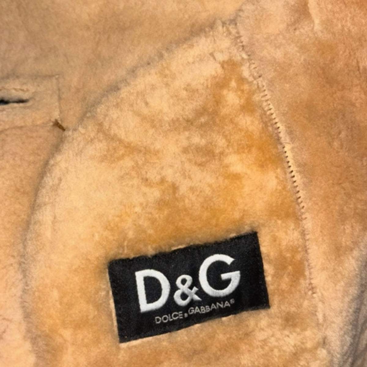 Fivedotsvintage D&G Dolce & Gabbana jacket interior featuring a black brand label on plush cream-colored shearling